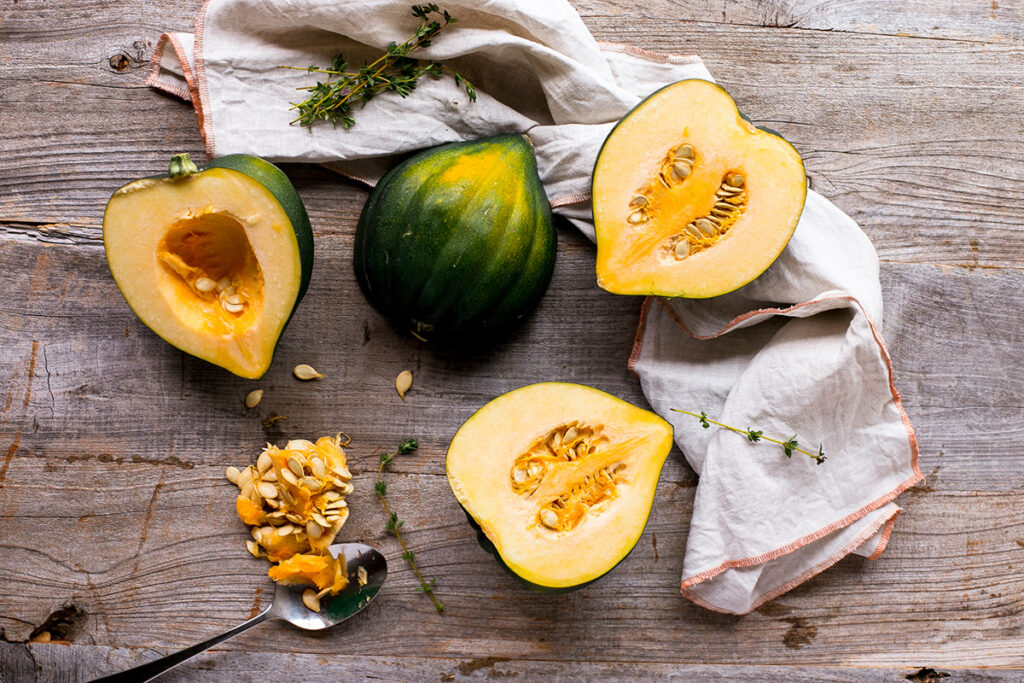 Ripe acorn squash cut in half with the seeds visible. You can easily save seeds from pumpkins, squash, and other gourds.